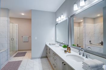 A bathroom with a white sink and a large mirror.